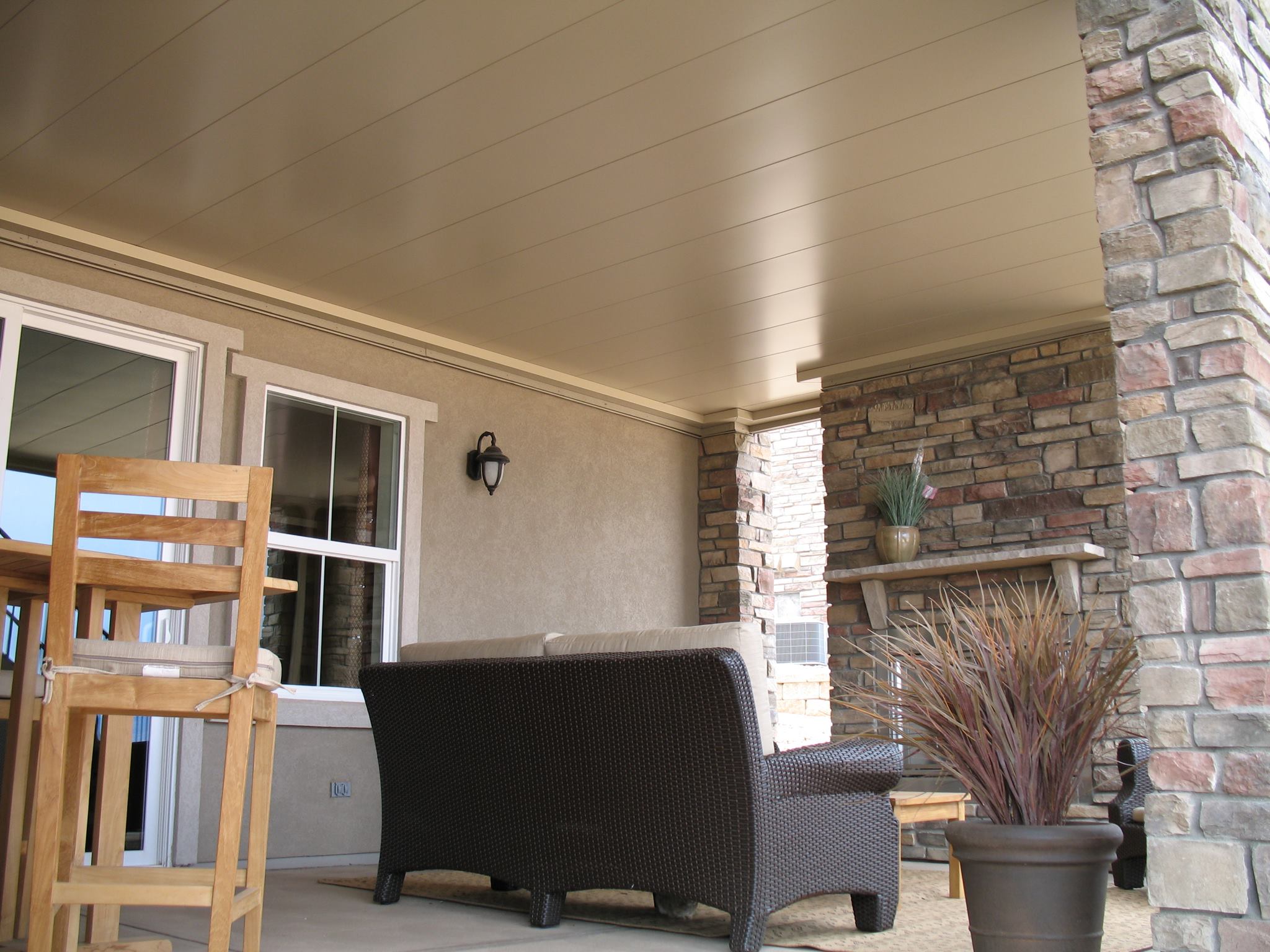 Finished underdeck ceiling panel system with stone and furniture