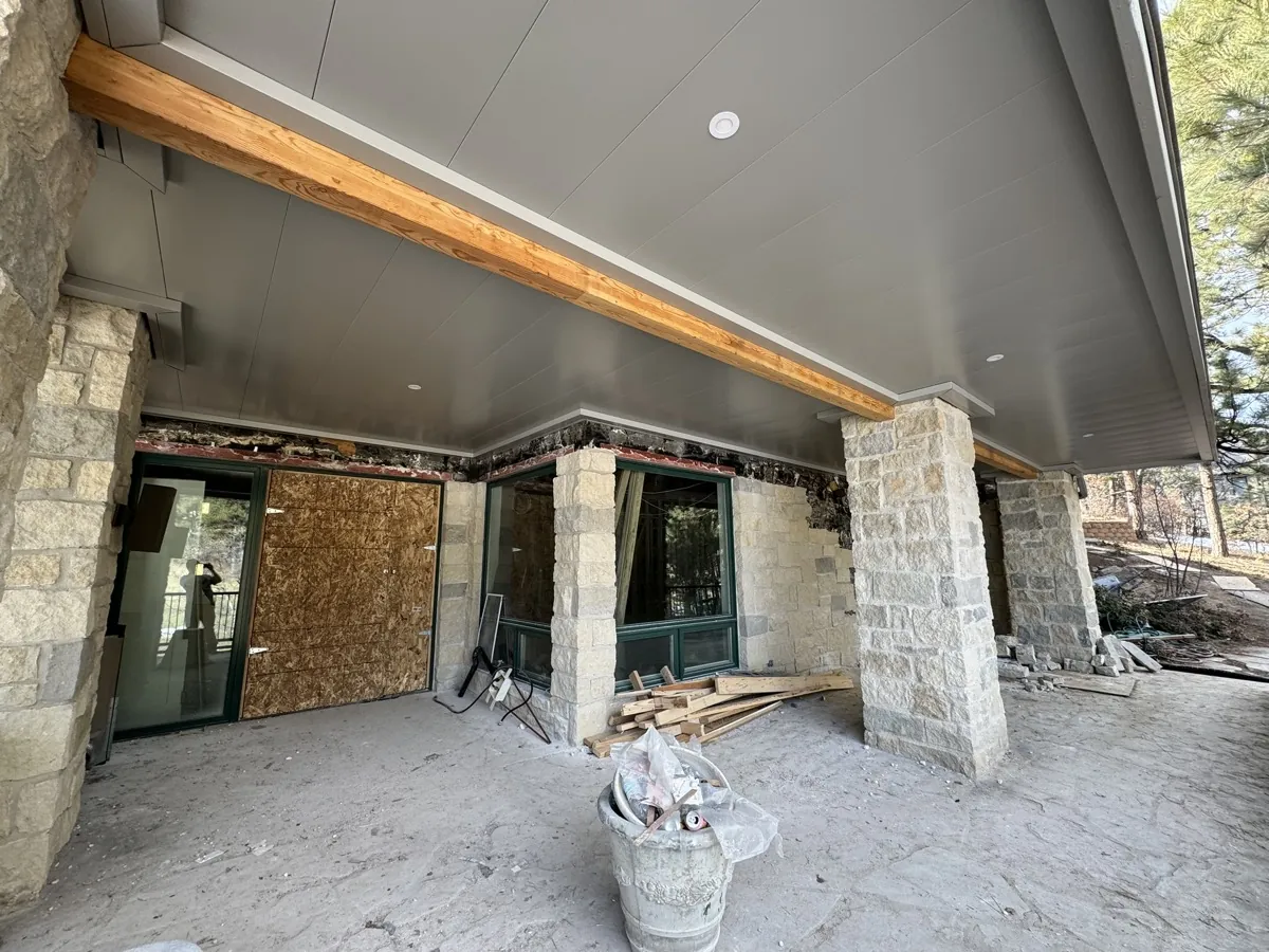 Commercial underdeck install with structural stone columns on a Colorado clubhouse build