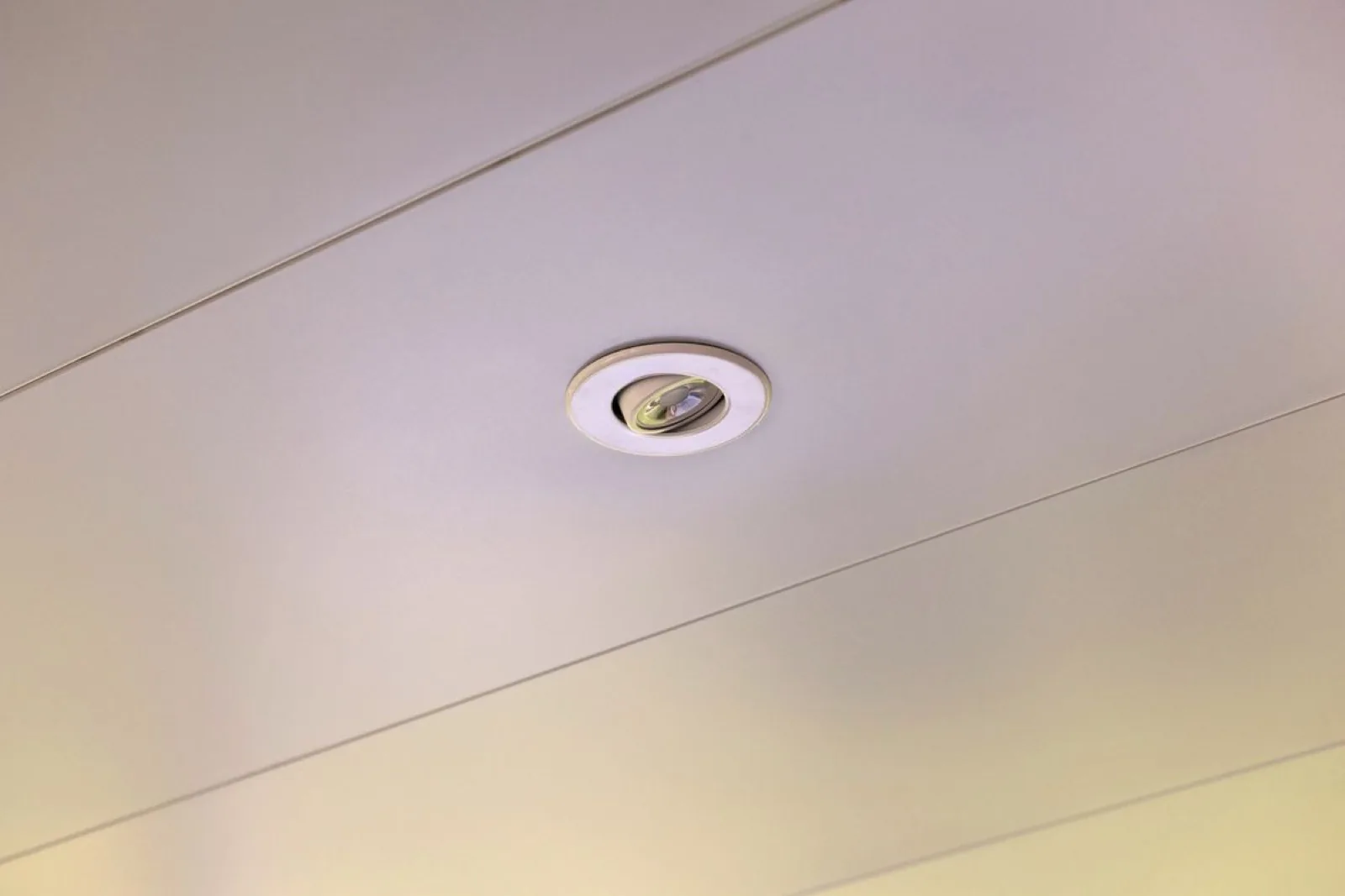 Recessed LED eyeball downlight flush-mounted in a white Undercover Systems panel ceiling
