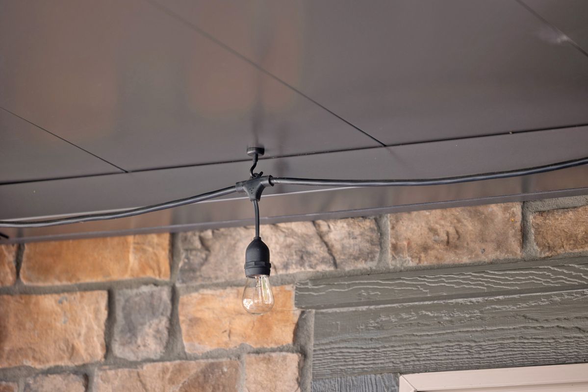 Bistro string lights mounted with magnetic hooks under an Undercover Systems ceiling