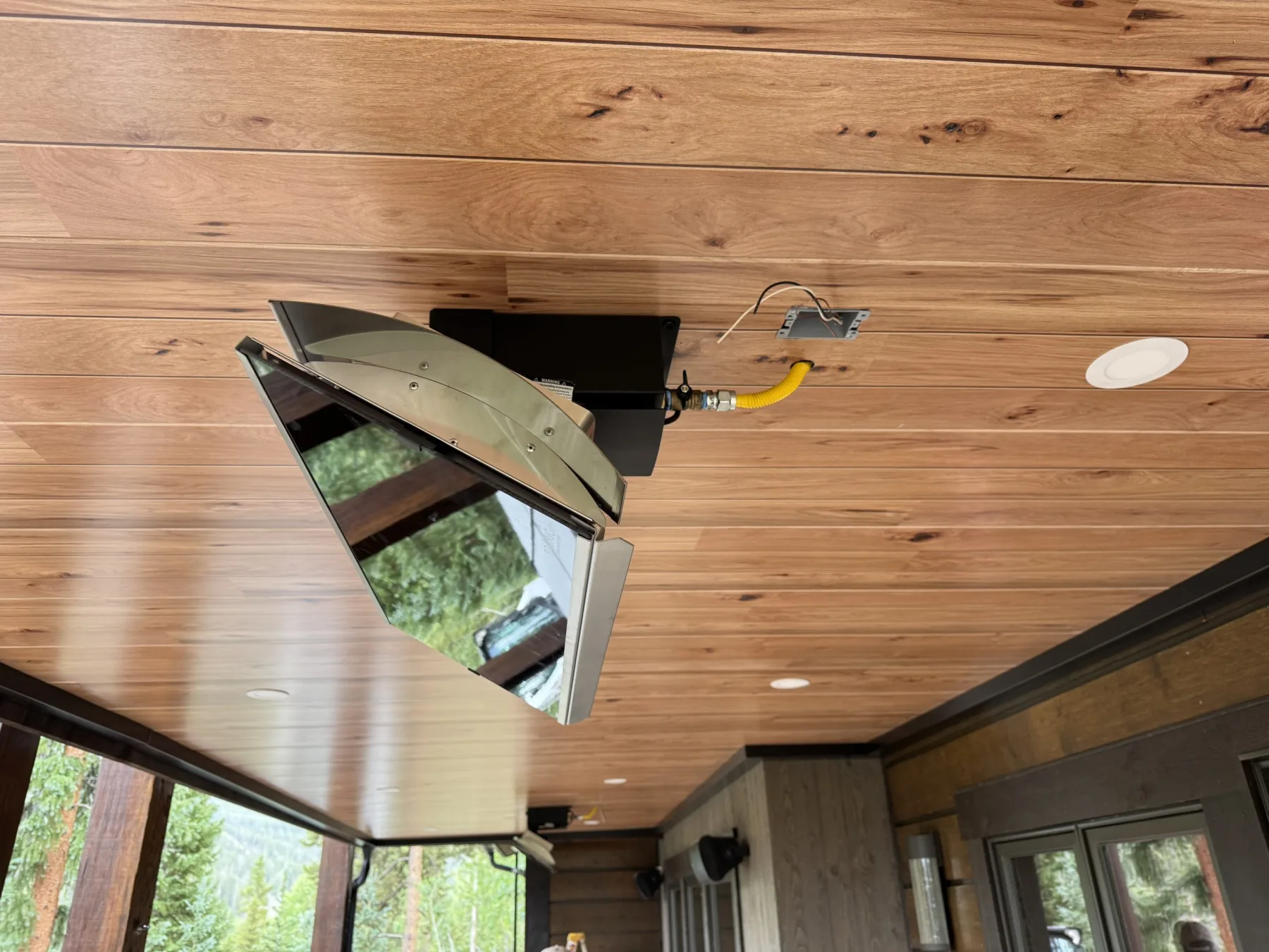 Wall-mounted gas heater integrated into a wood-finish underdeck ceiling